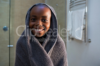 Portrait of smiling boy wrapped in gray towel