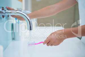 Cropped image of girl washing toothbrush