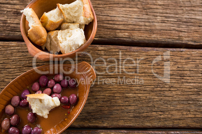 Marinated olives and bread pieces in bowl