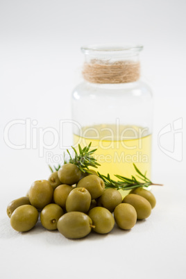 Marinated olives with oil bottle and herb