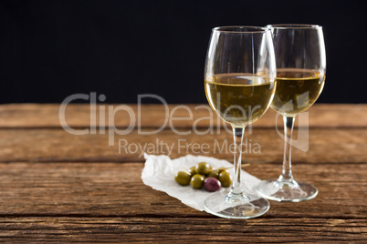 Close-up of olives with glasses of wine