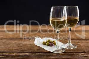 Close-up of olives with glasses of wine