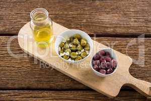 Marinated olives in bowl on chopping board