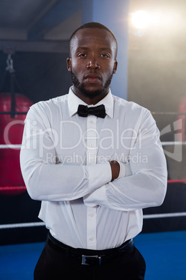 Portrait of young male referee standing with arms crossed