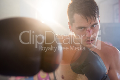 Young male boxer punching with bleeding nose