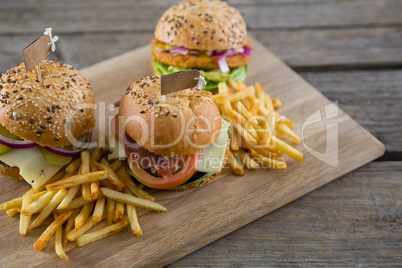 High angle view of burgers with french fries served on cutting board