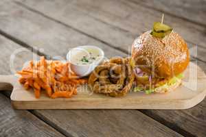 Hamburger by onion rings with dip and french fries