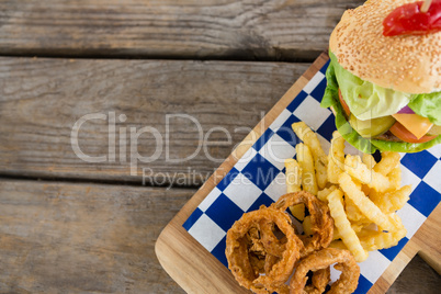 Overhead view of fried onion rings with french fries by burger