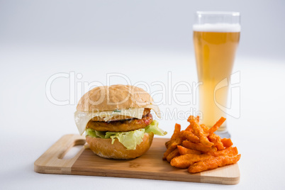 Burger with spicy French fries by beer glass