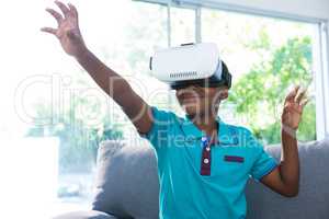 Boy wearing virtual reality headset gesturing at home