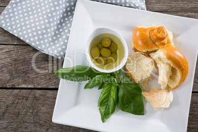 Pickled olives with herbs and bread in platter