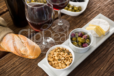 Close-up of marinated olives with glasses of wine