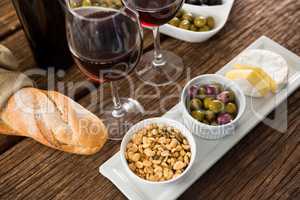 Close-up of marinated olives with glasses of wine