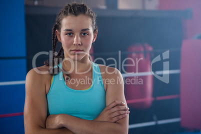 Portrait of confident young female athlete with arms crossed