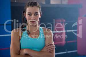 Portrait of confident young female athlete with arms crossed