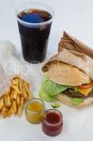 Close-up of hamburger, french fries, sauce and cold drink