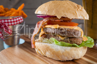 Hamburger and french fries on chopping board