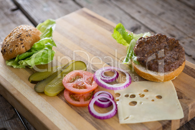 Vegetables with cheese and bun on cutting board