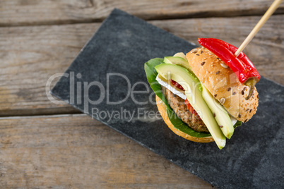 Overhead view of Burger with jalapeno pepper on slate