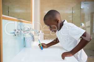 Side view of boy spitting in sink