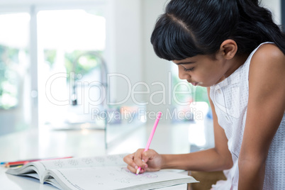 Side view of girl drawing in book