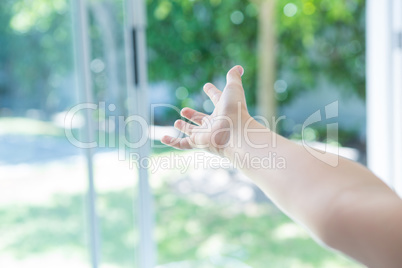 Cropped image of hand reaching window