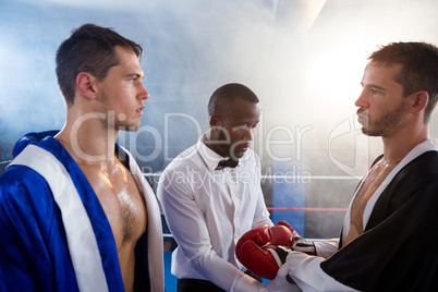 Referee checking gloves of male boxer