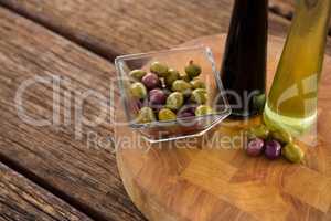 Marinated olives with olive oil and balsamic vinegar bottles on table