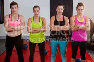 Portrait of female athletes standing with arms crossed on exercise mat
