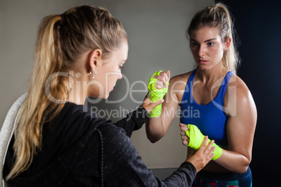 Trainer assisting woman in boxing