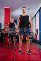 Young athletes lifting barbells on exercise mats