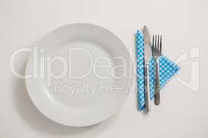 Plate with eating utensils and napkin