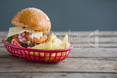 Cheeseburger and French fries in basket