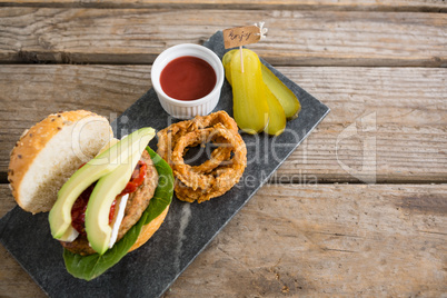 High angle veiw onion rings with burger on slate