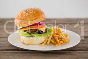 Cheeseburger served with French fries in plate