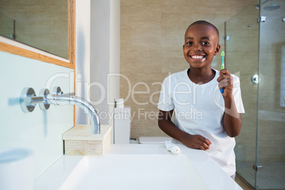 Portrait of smiling boy showing toothbrush
