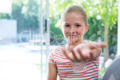 Portrait of girl sitting with arms raised