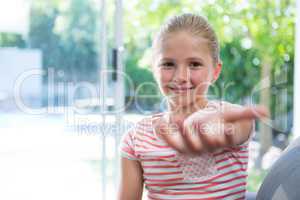 Portrait of girl sitting with arms raised