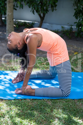 Side view of girl exercising in yard