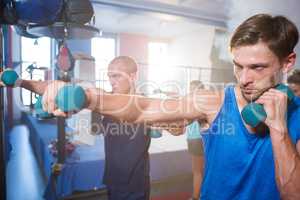 Young male athletes punching with dumbbells