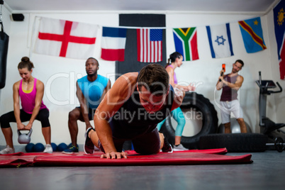 Young male athlete praticing push ups on exercise mat