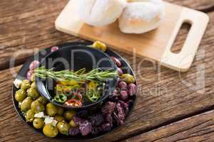 Pickled olives and vegetables with rosemary in bowl
