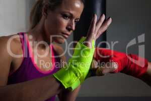 Trainer assisting woman in boxing