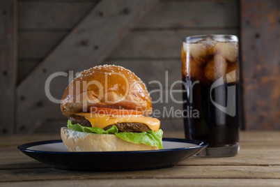 Hamburger in plate with glass of cold drink