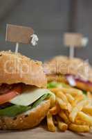Hamburger with tag and french fries on wooden table