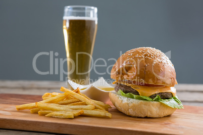 Close up of cheeseburger with french fries and beer glass