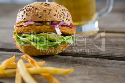 Close up of burger by fries and beer