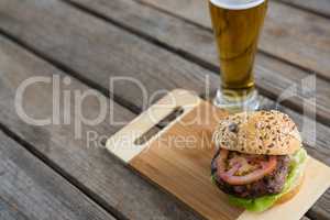 High angle view of hamburger on cutting board by beer