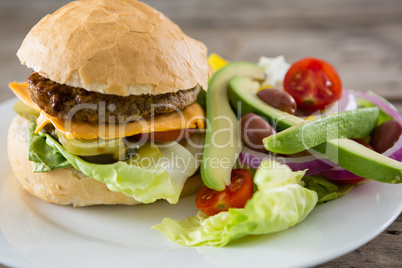 Close up of cheeseburger with salad and french fries