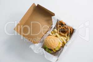 Burger with onion rings and French fries in box